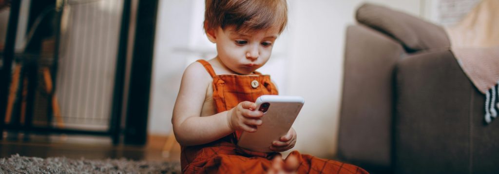Young child using a phone - tips from Blue Windmill Nursery how to manage online risks for young children 