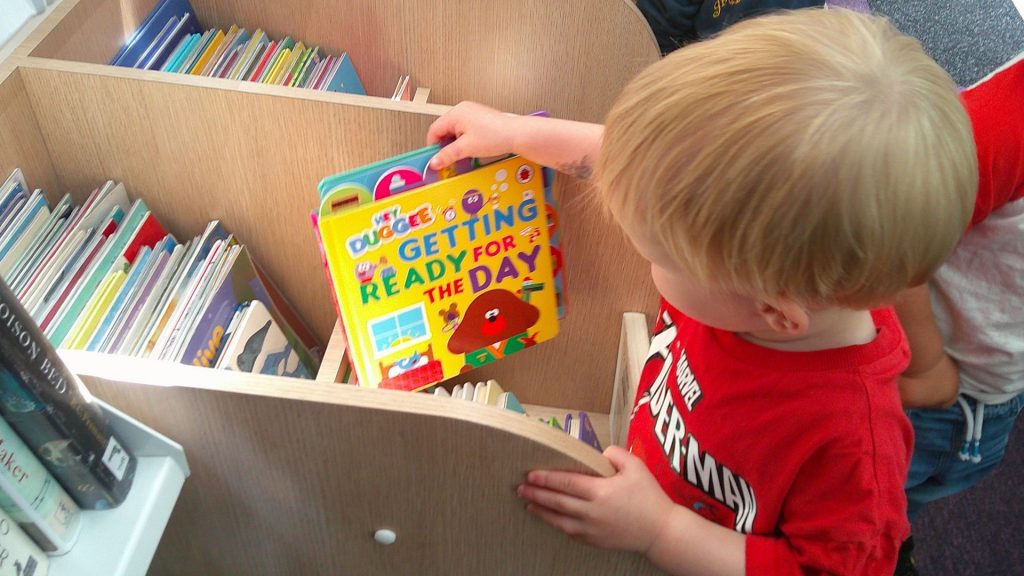 Baby choosing a book from Rugby mobile library